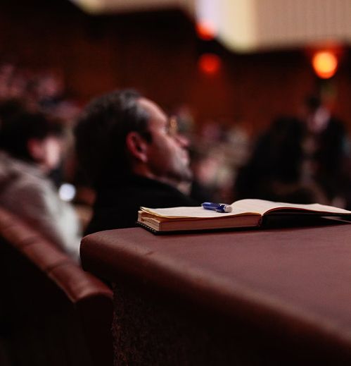Notebook and pen with a man in the background