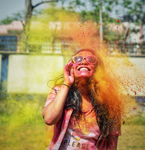 Woman covered in colorful powder at a festival